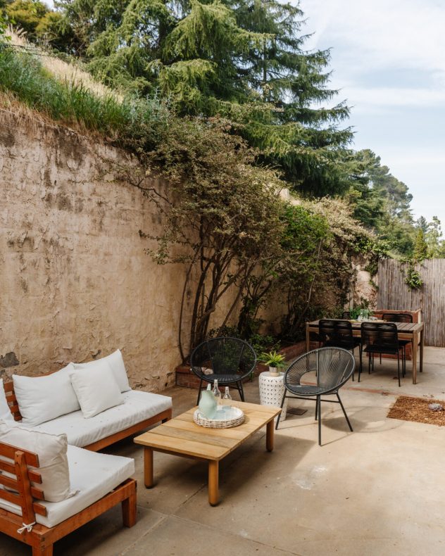 Private backyard with outdoor seating area and hillside setting, ideal for relaxing or entertaining