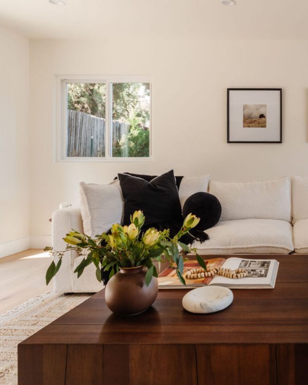Open living room adjacent to kitchen with balcony and views of the Los Angeles skyline
